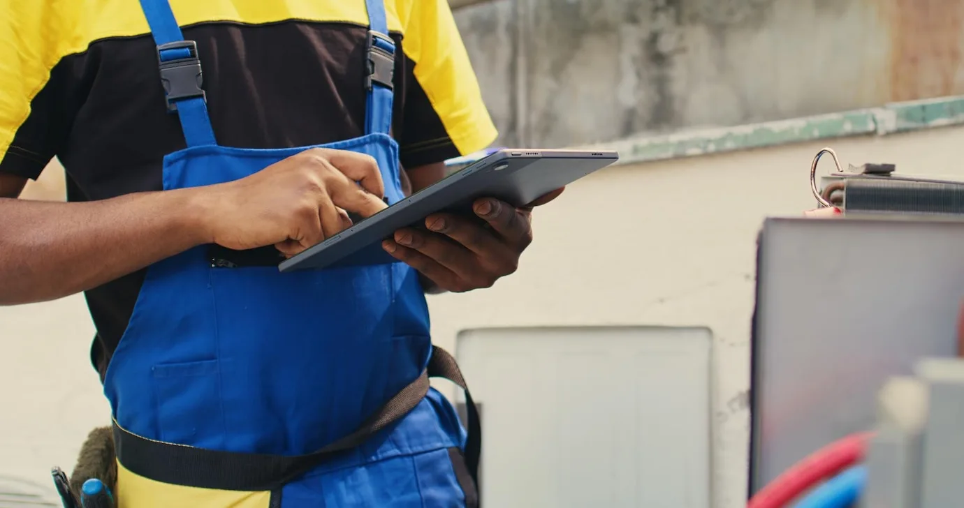 An HVAC technician setting up a scheduled maintenance plan for client