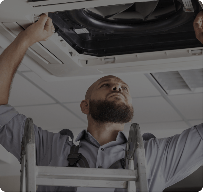 HVAC technician repairing an outdoor air conditioning unit in Niagara, Ontario