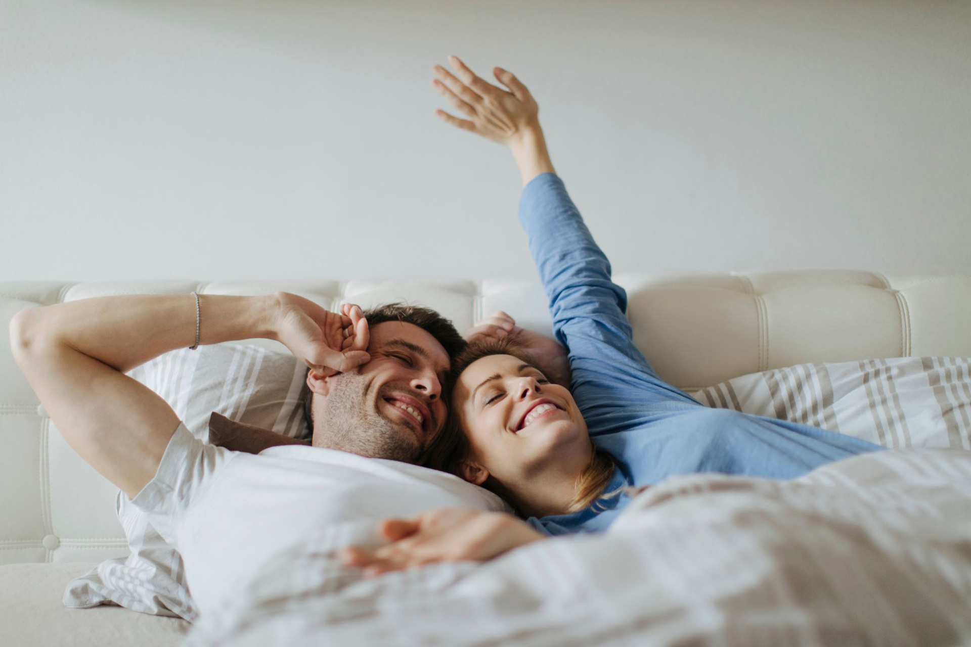 A couple waking up happily in bed