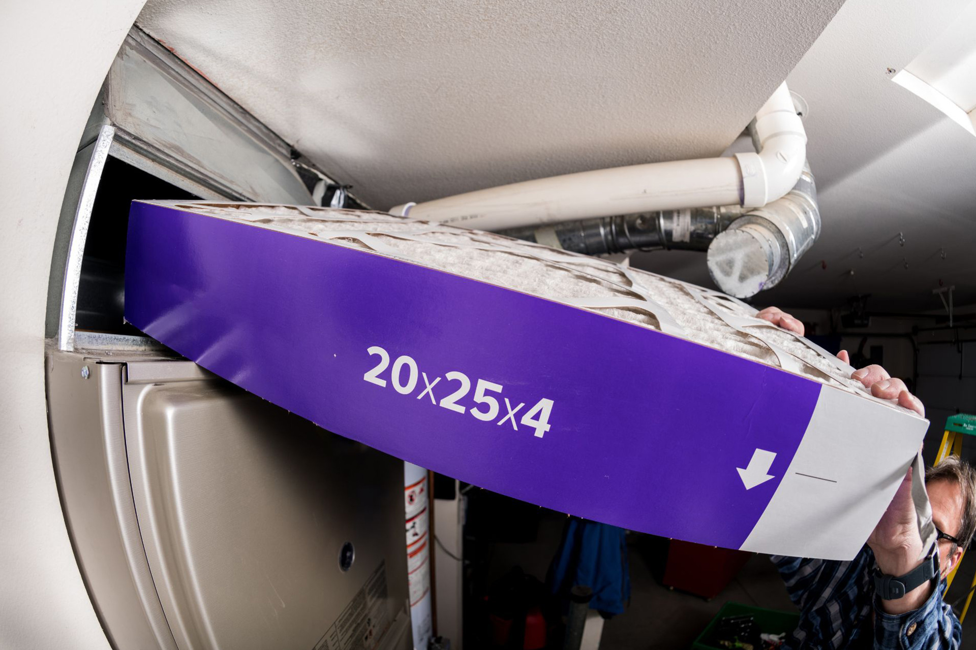 A man inserting a 20x25x4 allergy furnace filter into the unit
