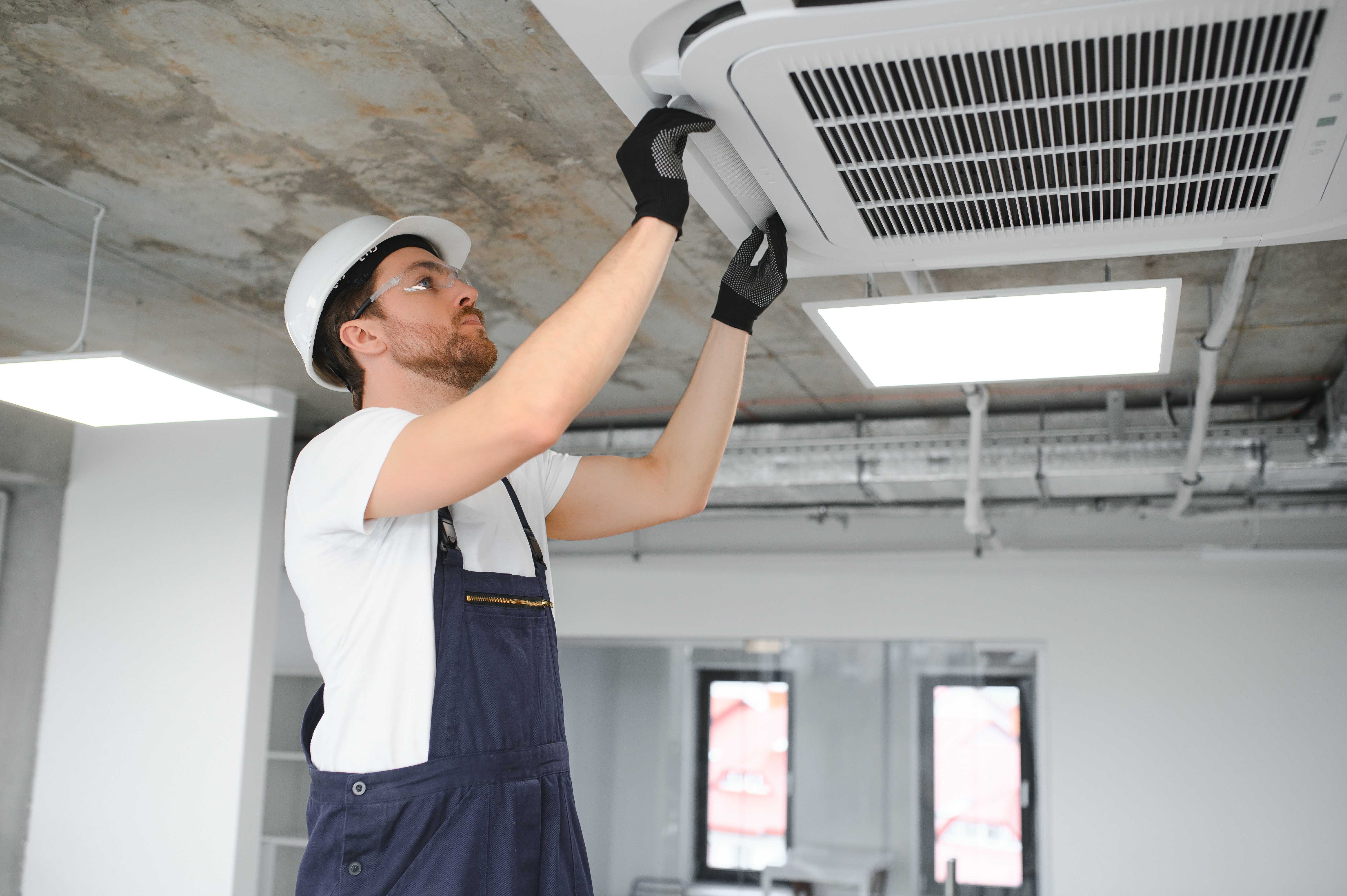 Happy Male Technician Repairing Air Conditioner