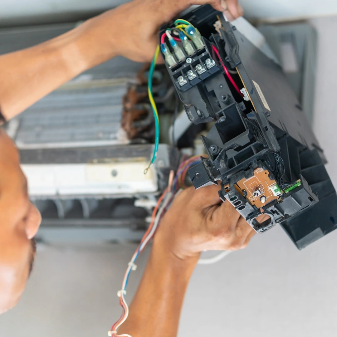 Professional HVAC technician taking apart a home air conditioner unit