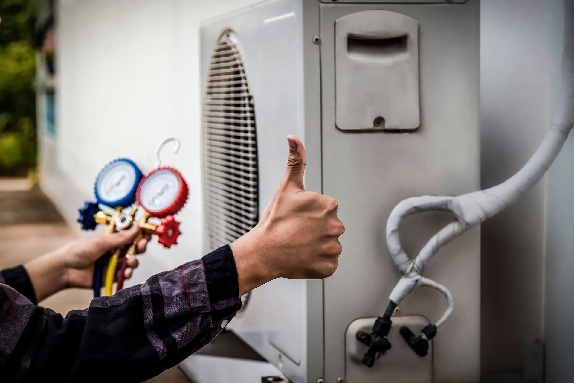 An HVAC technician giving a thumbs up after conducting HVAC maintenance