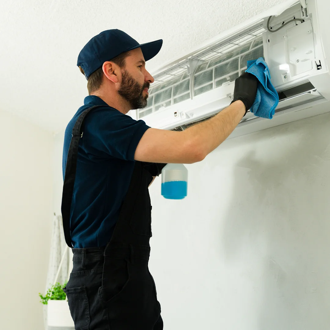 HVAC professional cleaning a home air conditioning system