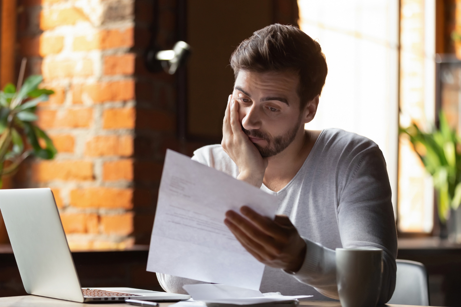 Frustrated young man reading a document or contract