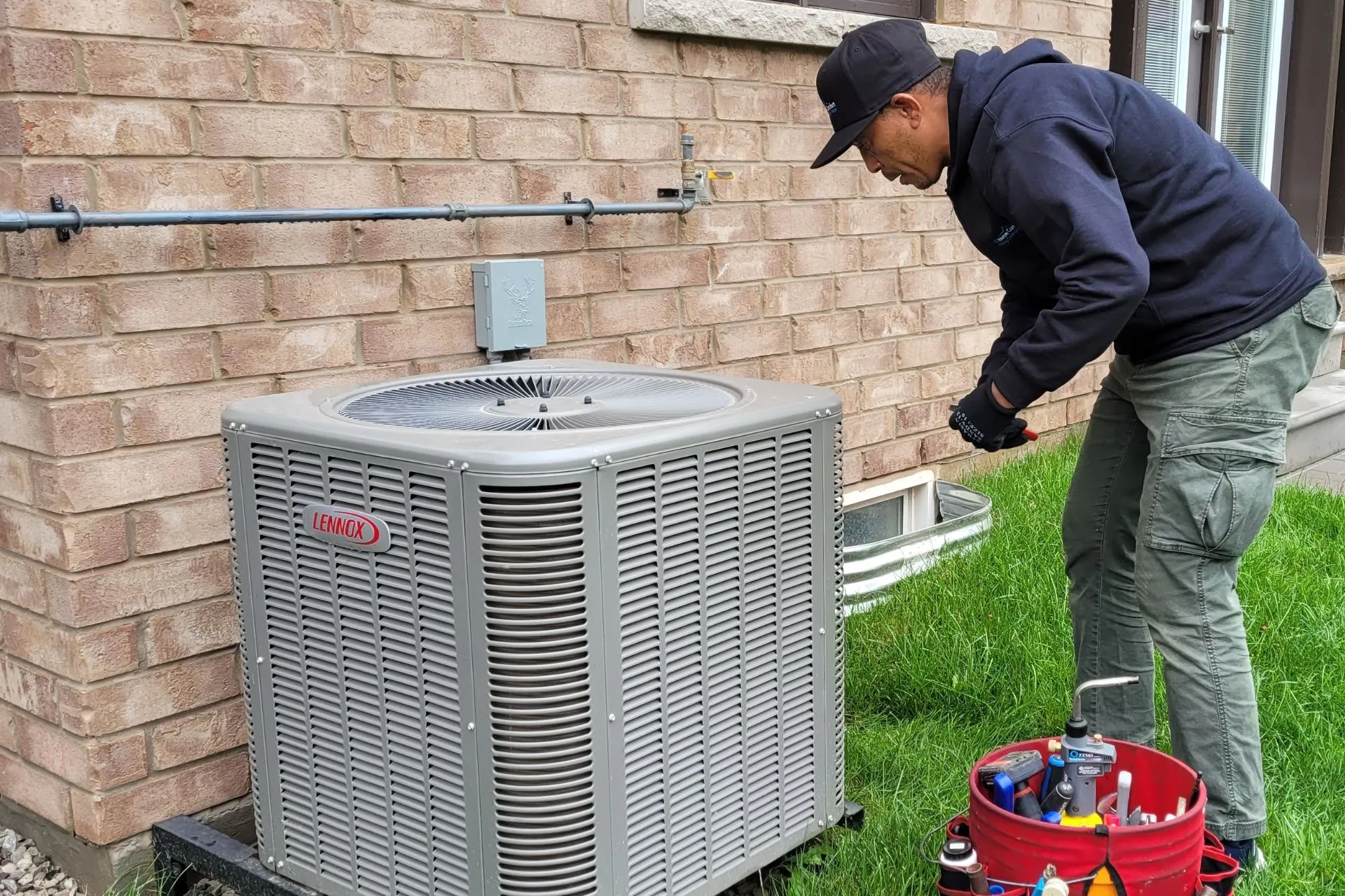 LG Home Comfort technician fixing outdoor unit in lawn
