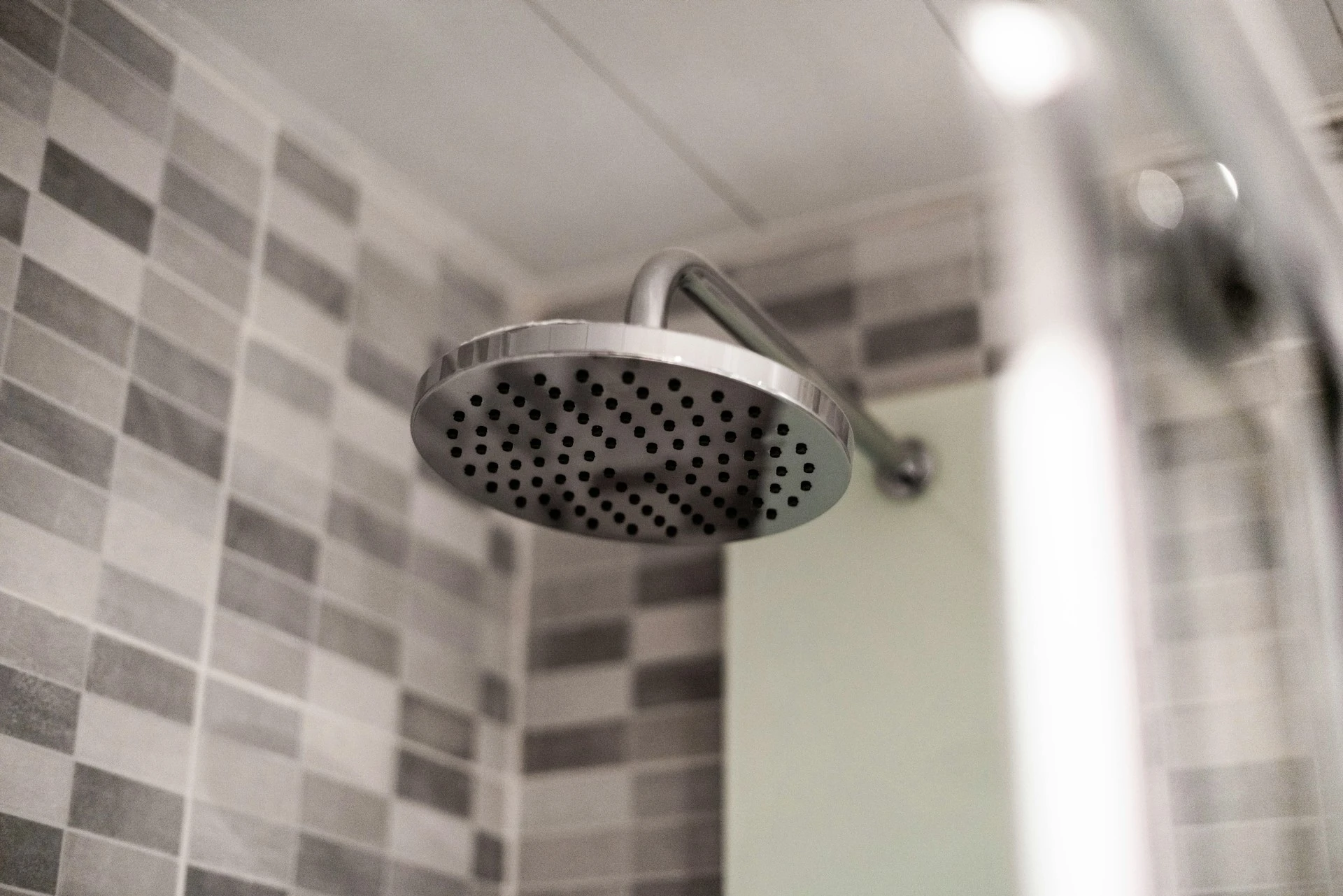 A grey stainless steel shower head